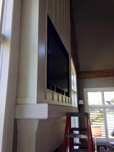 tv mounted above fireplace