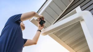 A man installing security cameras on a Utah home