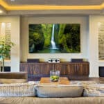 Home theater room with a large wall-mounted TV, speakers and sectional seating