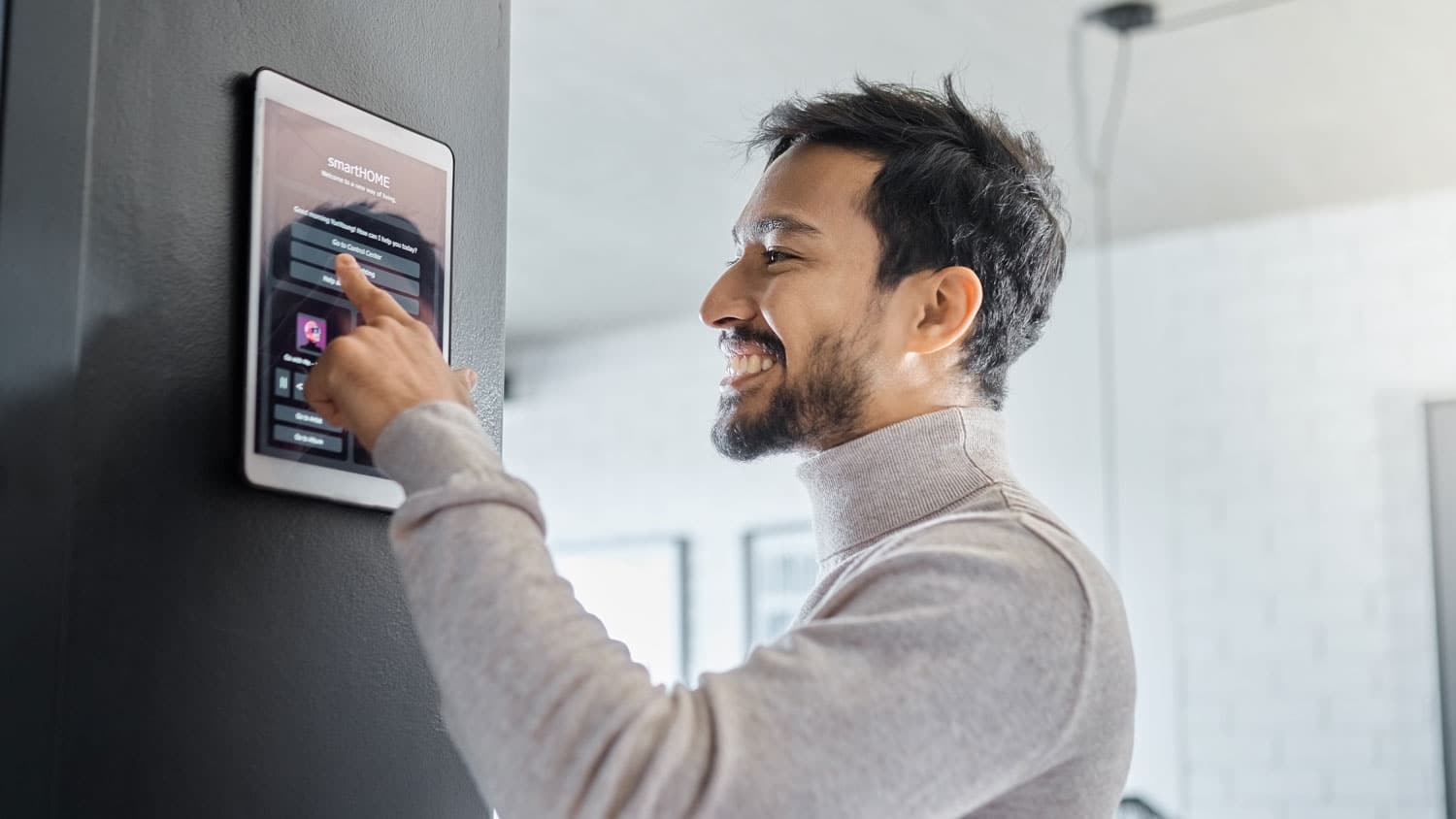 Homeowner using a wall-mounted smart home security system control panel
