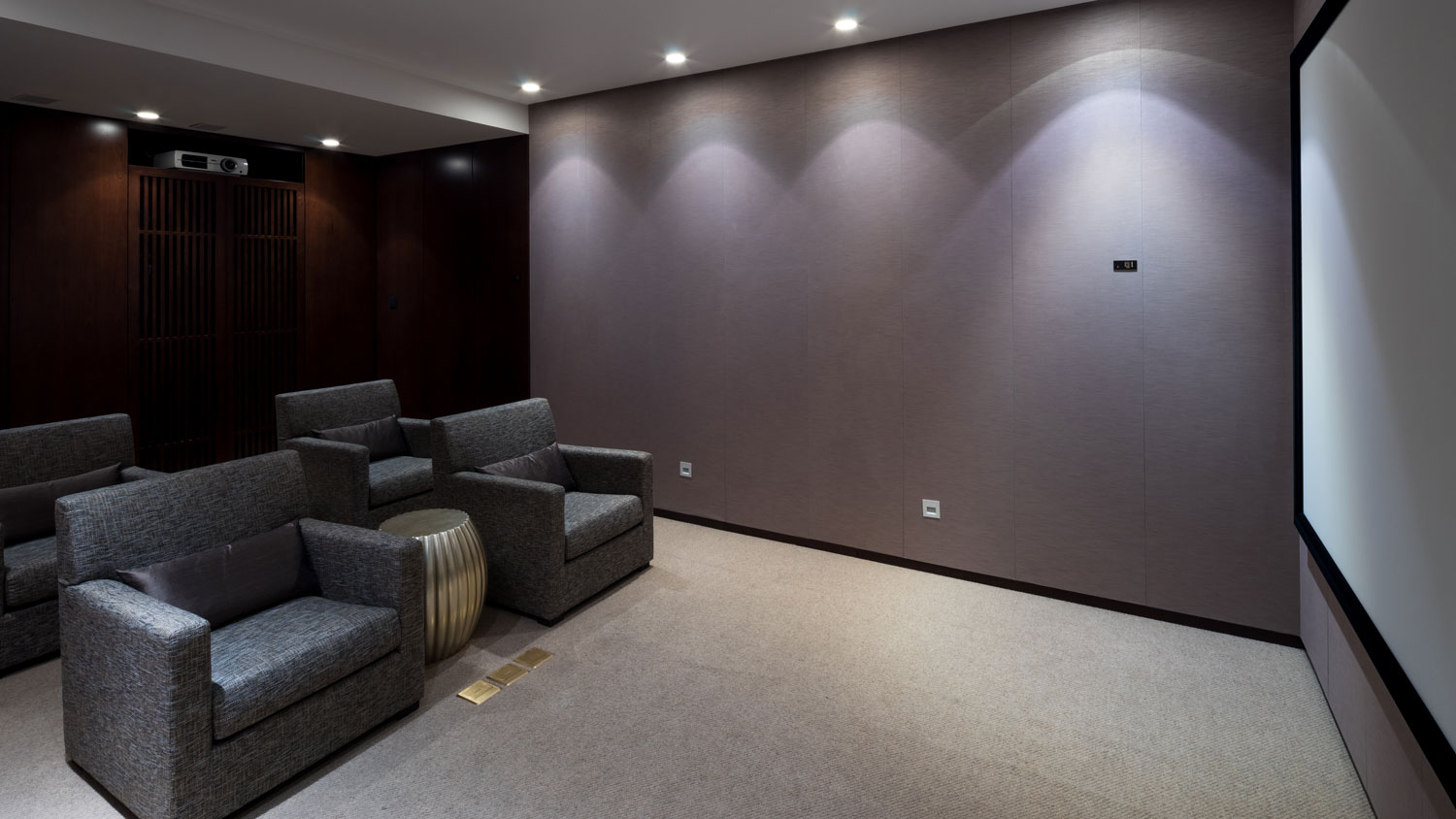 Custom home theater room with projector screen, individual seating and recessed lighting